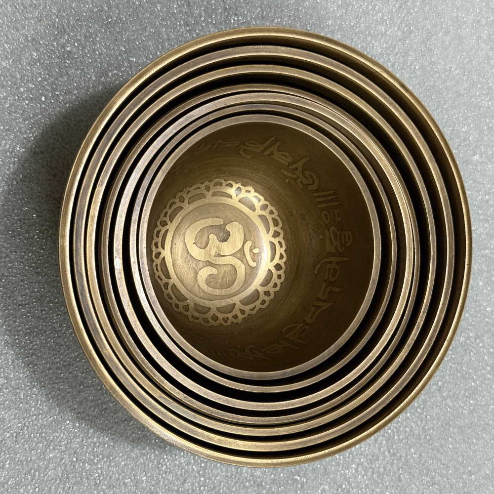Tibetan Singing Bowl Set of 7 — Mantra Carved Bronze Chakra Bowls, Handmade in Nepal mantra carved bronze singing bowl close up